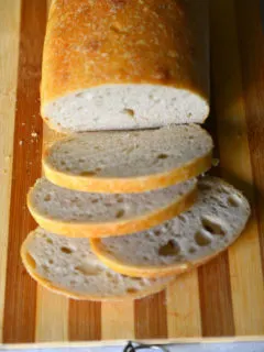 Sliced loaf of simple sourdough bread on a bread board