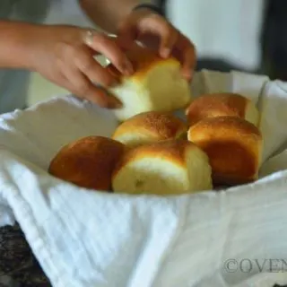 Placing buns in a bread basked lined with white towel