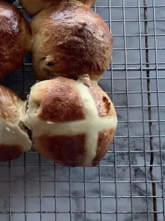 Hot Cross Buns resting on a cooling rack.