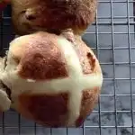 Hot Cross buns on a cooling rack. Image with caption "Light and healthy hot cross Buns"