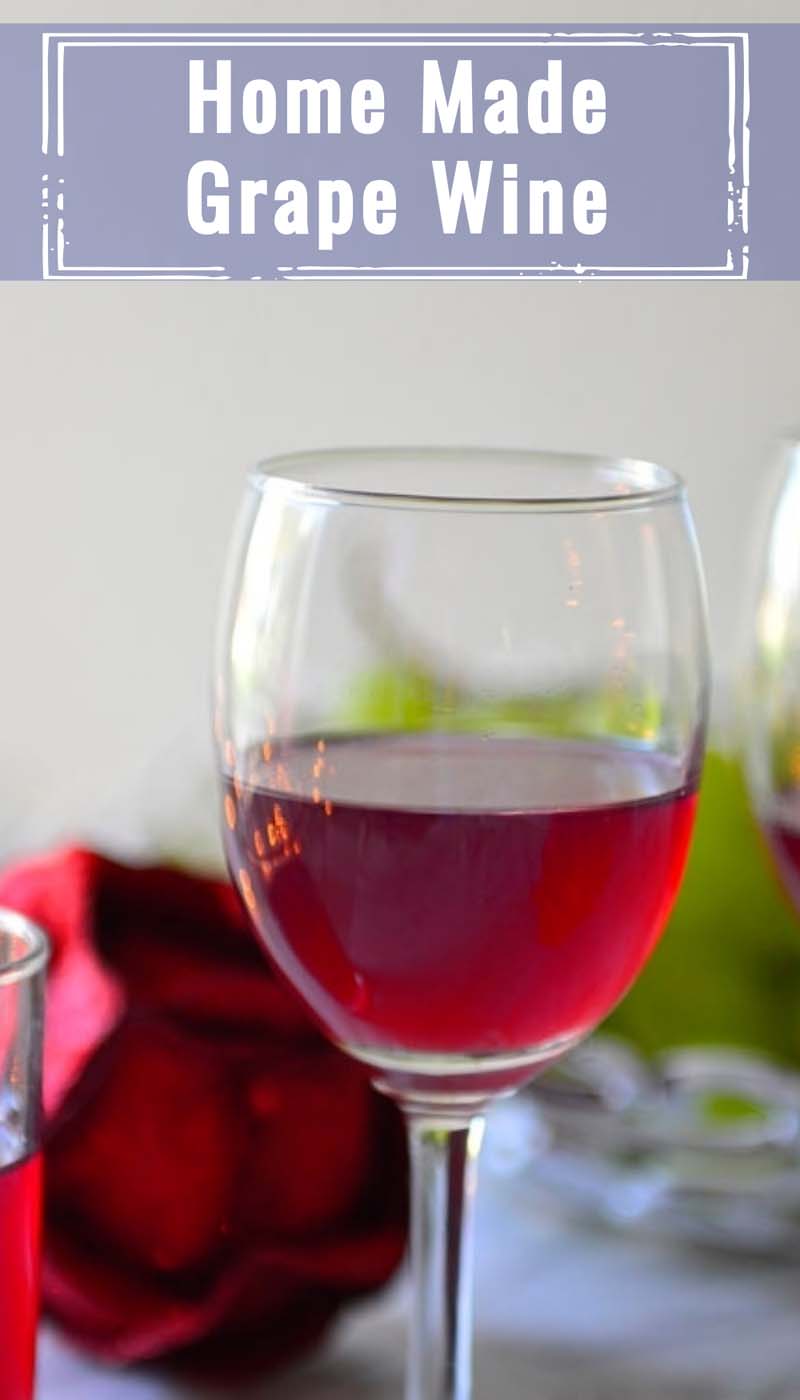 A glass of red wine and with a red glitter flower in the back ground. Caption - Home Made Grape Wine. Image for pinning