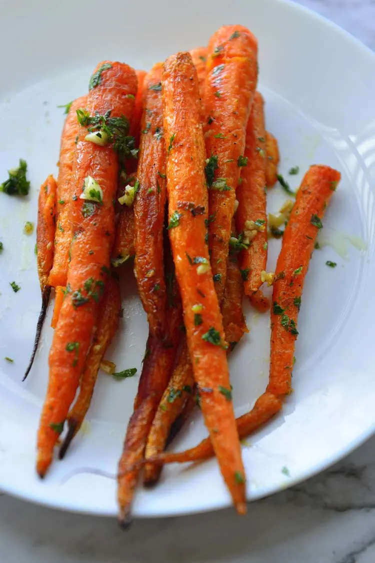 Roast carrots piled on a white plate