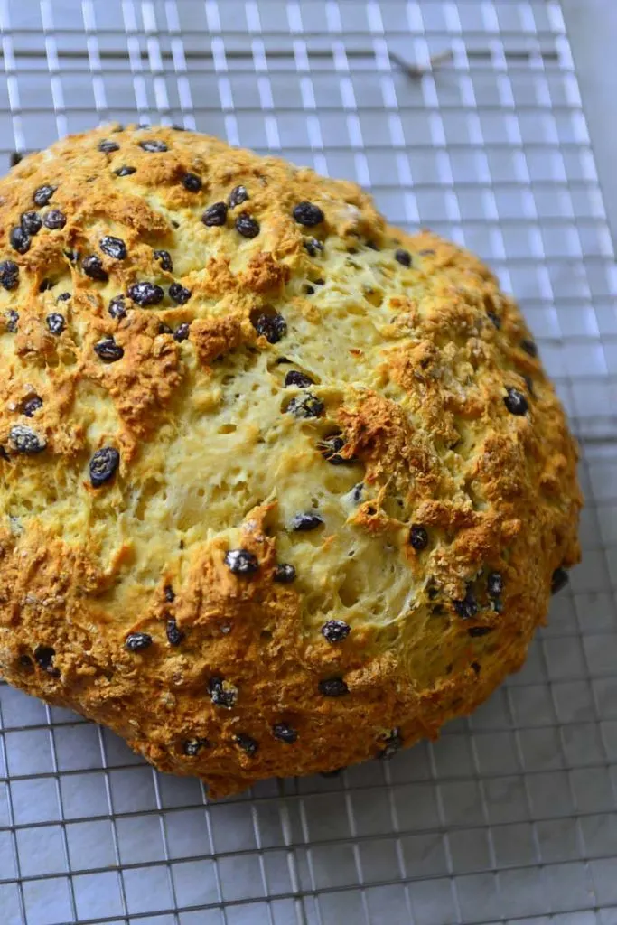 A loaf of Irish Soda bread resting on a cooling rack 