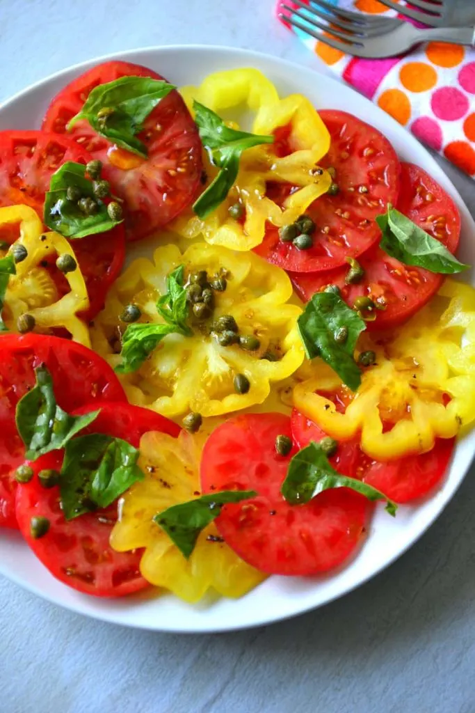 Garden Tomato Salad made with sliced colorful heirloom tomatoes on a plate 