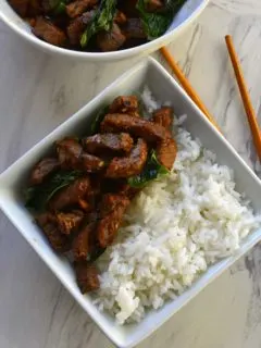 A bowl of stir fried beef and rice.