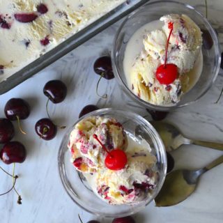 Two bowls of frozen cherry custard with a tub of custard in the background.