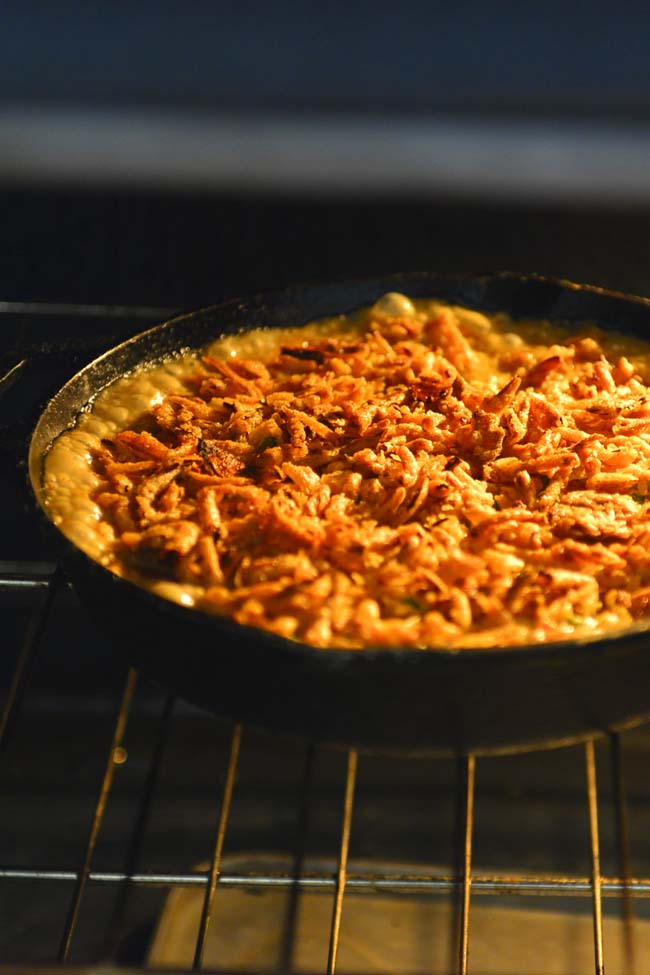 Green Bean Casserole in a cast iron skillet baking in the oven