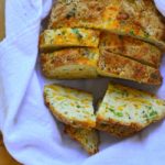 Sliced Green Onions and cheese soda bread in a bread basket .