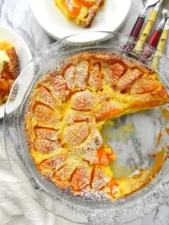 Apricot Clafoutis on a pie plate with a wedge removed.