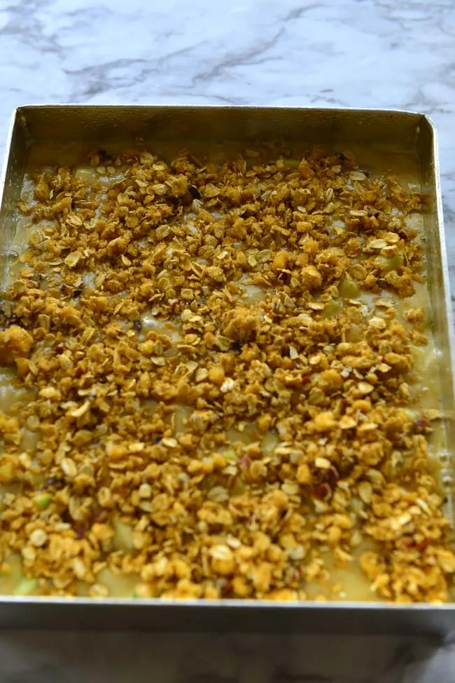 Cake batter spread in the pan with crunchy streusel topping, ready for the oven