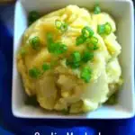Mashed potatoes in a white bowl along with caption - Garlic Mashed Potatoes | Vegan