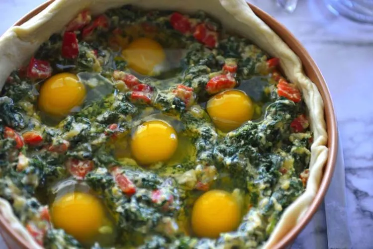 Egg and spinach filling in the pie shell uncovered.