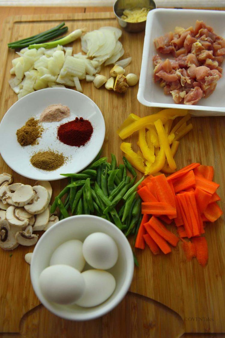 Ingredients for Khao Suey - chicken, spices, veggies, eggs, on a chopping board